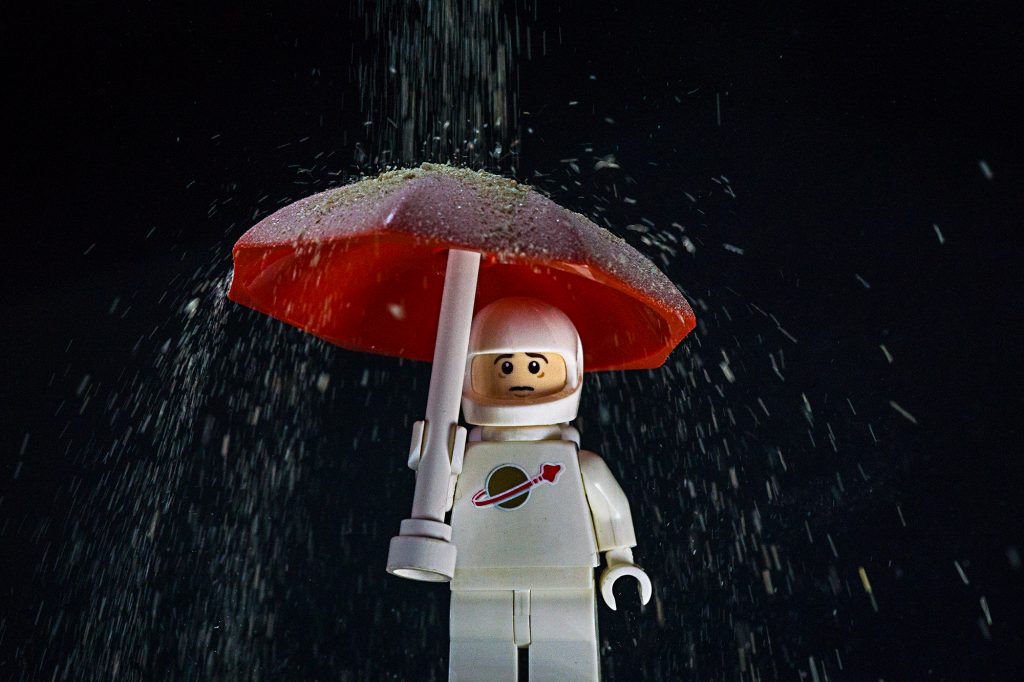 Spaceman under an umbrella, getting covered in dust, which is a distraction.