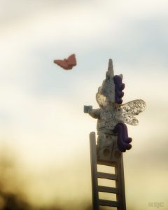 LEGO unicorna stands at the top of a LEGO ladder trying to catch a LEGO butterfly, photo by Shelly Corbett