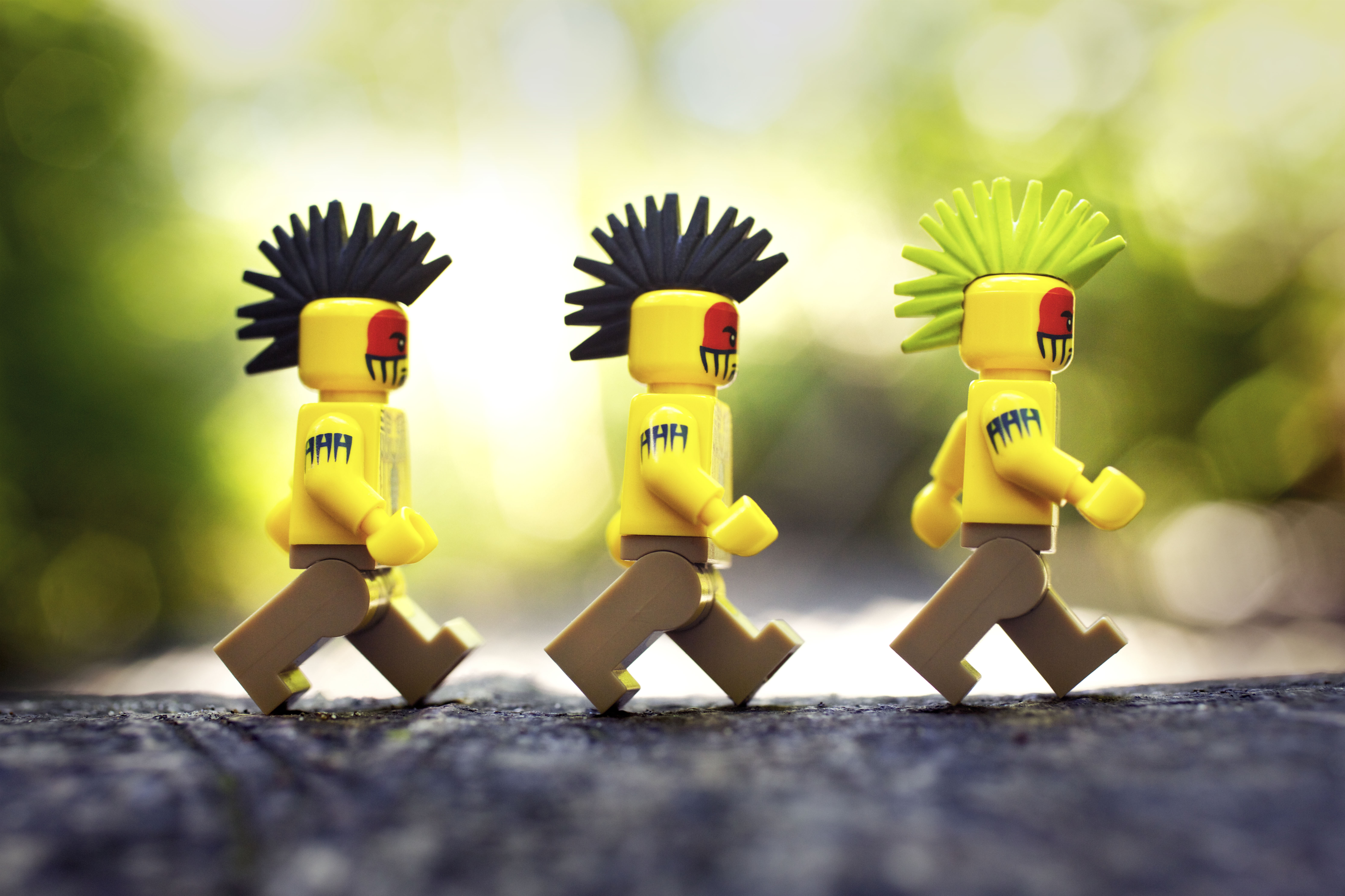 Three LEGO Indians with Mohawks walk in single file, photo by Shelly Corbett