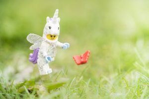 Lego unicorn with wings chases butterfly across grass photo by Shelly Corbett