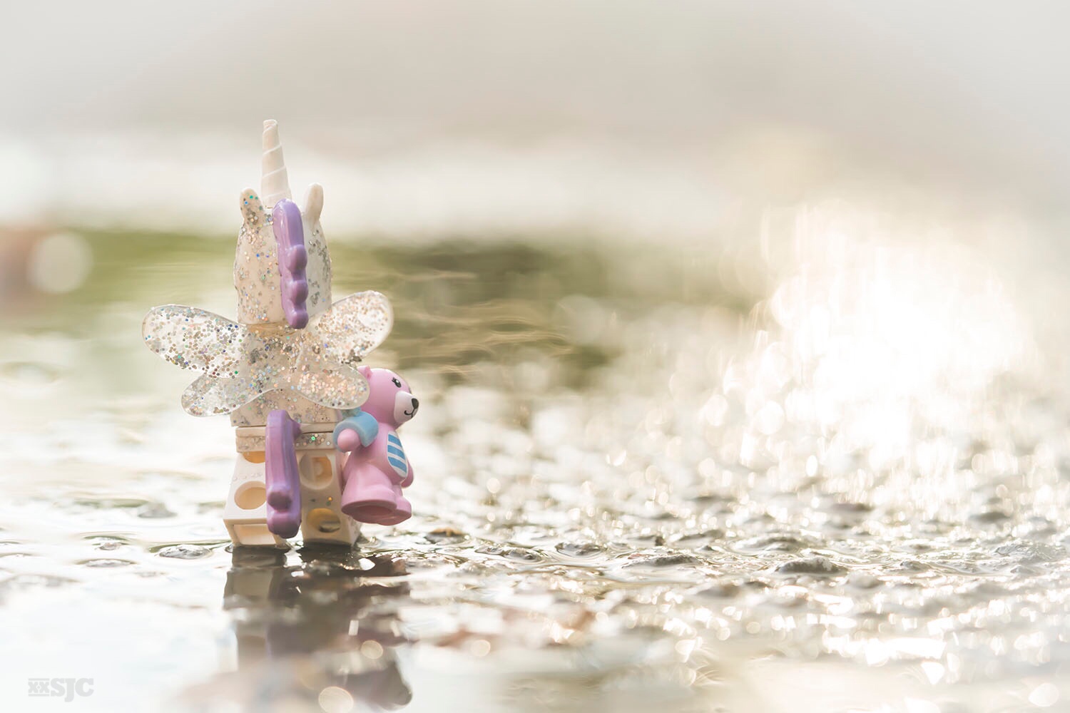LEGO Unicorn with wings walks away holding pink LEGO teddy bear