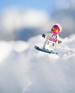 Female LEGO Snowboarder takes on the snowy half pipe on a bright sunny day. Photo by Shelly Corbett