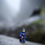 blue LEGO spaceman holds teddybear and looks afraid, taken with a lensbaby by Shelly Corbett
