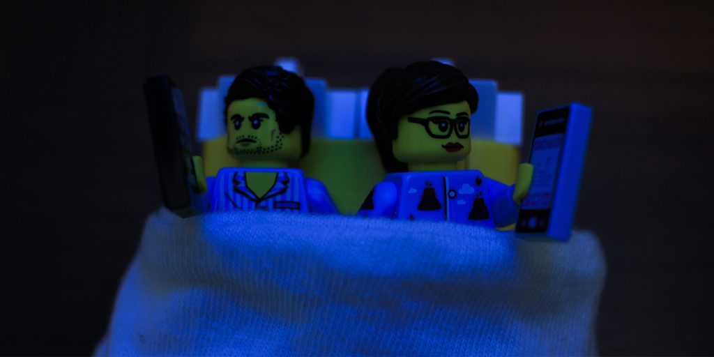 LEGO minifigures in bed on phones together by James Garcia