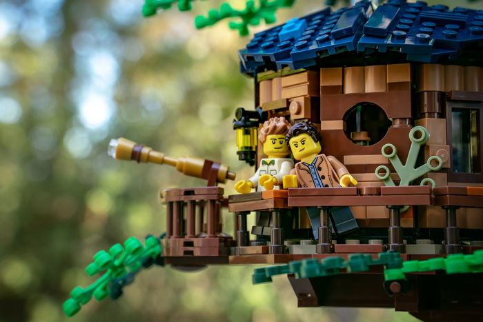 Treehouse owners stand on the balcony and look out over the forest.
