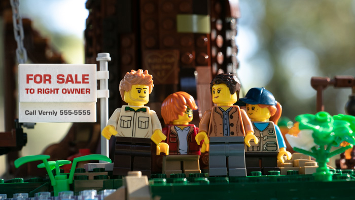The original LEGO Ideas treehouse family stands next to a For Sale sign.