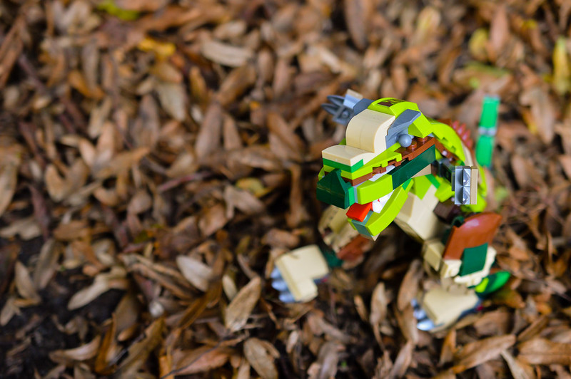 LEGO dinosaur playing in the autumn leaves