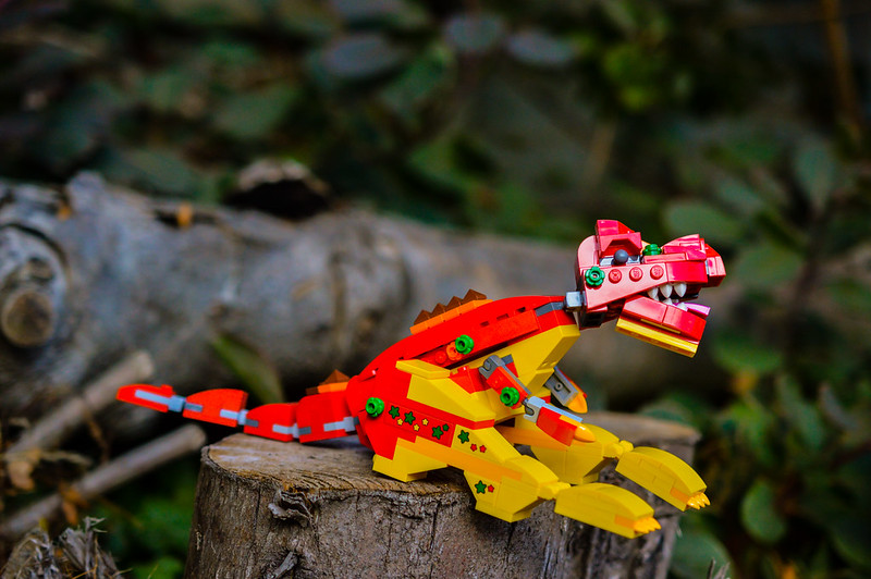 LEGO dinosaur sitting on a log