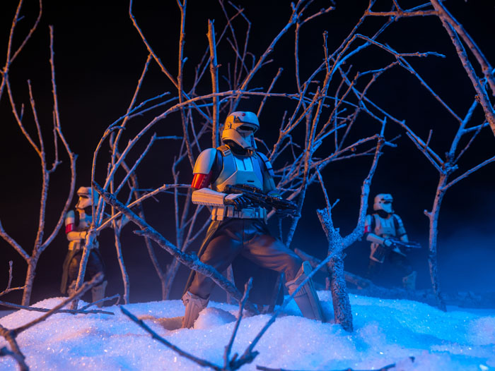 Scarif troopers patrolling through the misty woods in the snow.