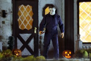 Mezco One:12 Collective Michael Myers action figure in front of large house closest saturated