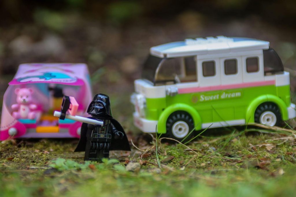 LEGO Darth Vader minifigure taking selfie in front of LEGO Freinds tent and a camper