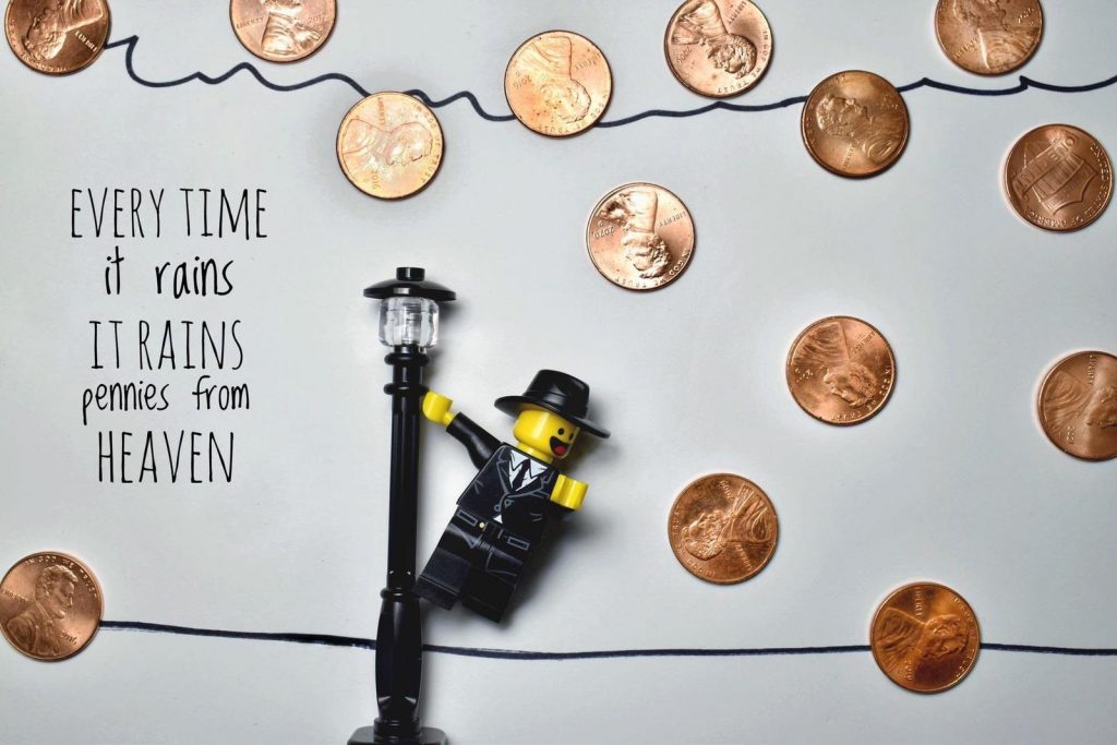 Lego minifigure stylized as Gene Kelly in Singin' in the Rain with pennies put like they're falling from the sky