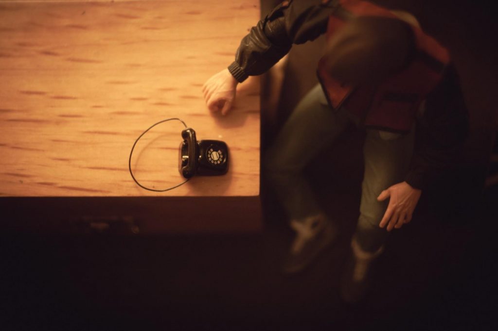 Marty McFly action figure sitting by the phone, aerial pov