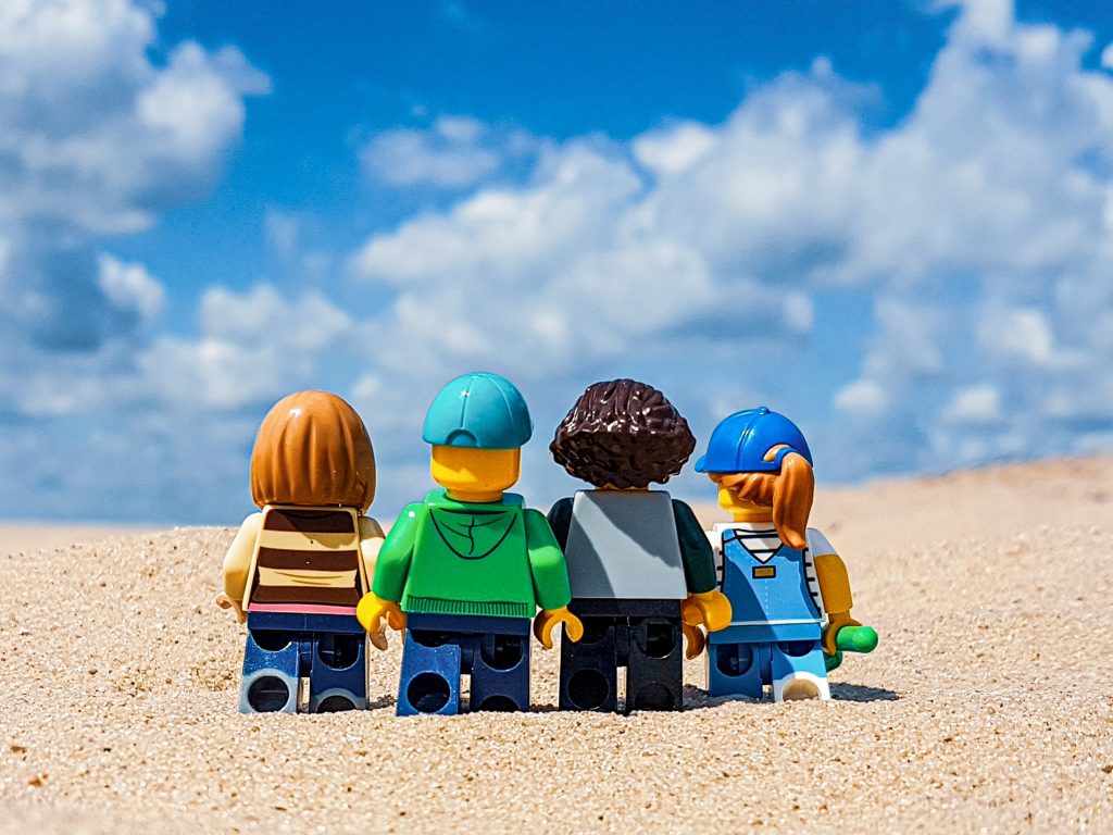 A family of LEGO minifigures photographed walking towards the horizon.