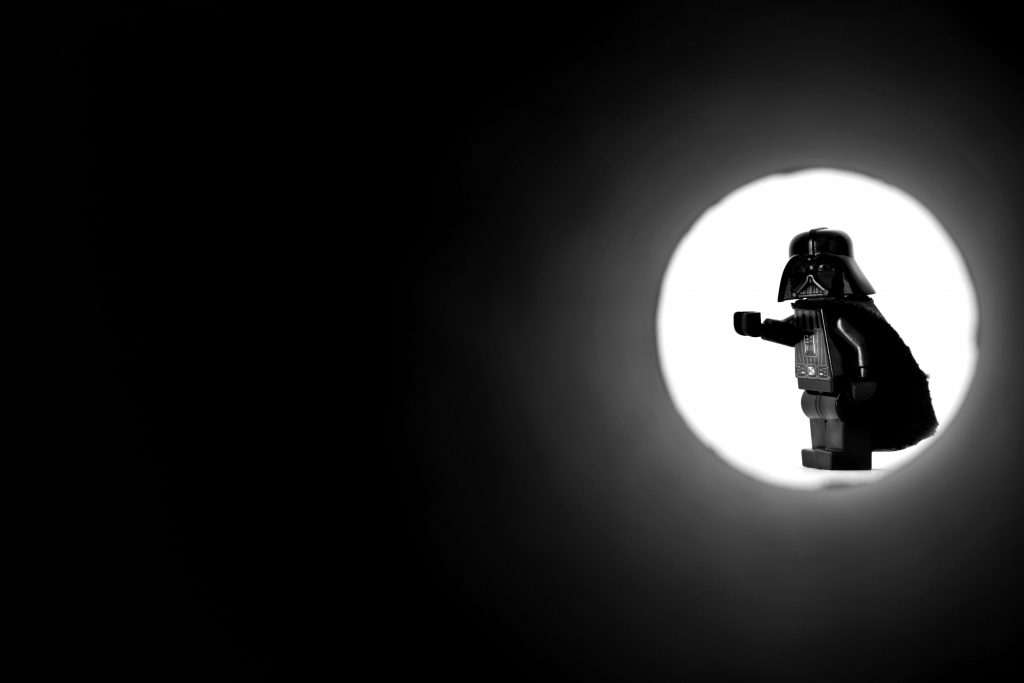 Black and white picture of LEGO Lord Vader minifigure in James Bond opening sequence-like perspective