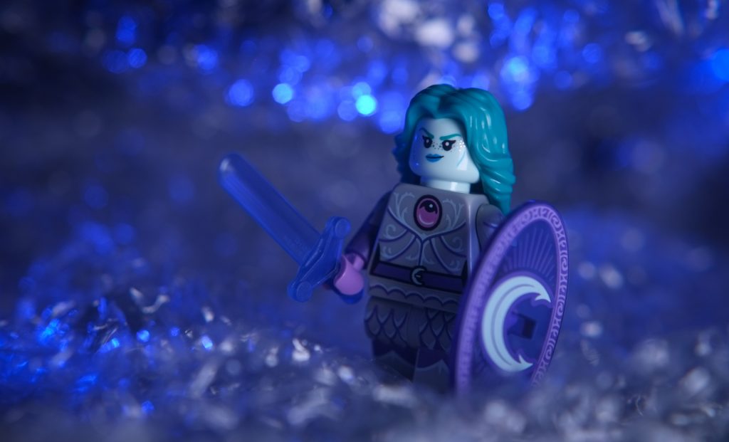 LEGO female warrior minifigure with blue transparent sword and shield