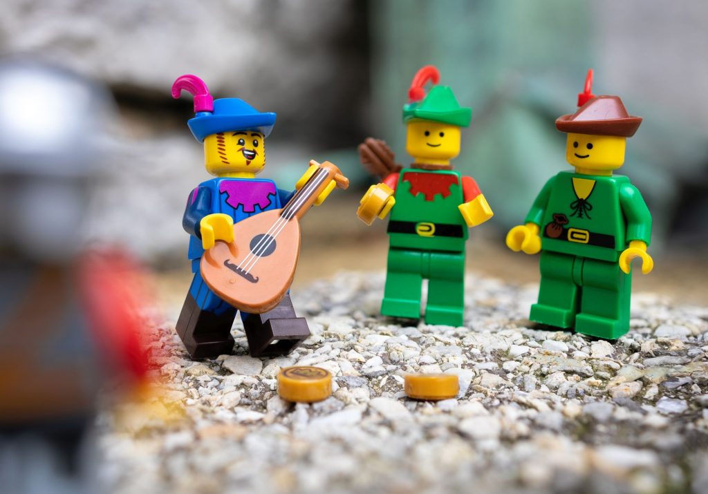 LEGO bard minifigure singing and playing lute for a group of LEGO forestmen minifigures.