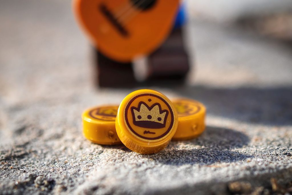 Three LEGO coins lying on the rock