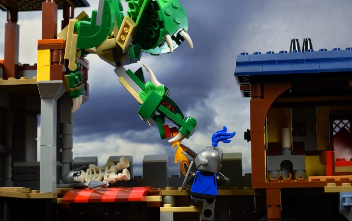 LEGO brick built dragon attacking a LEGO castle walls