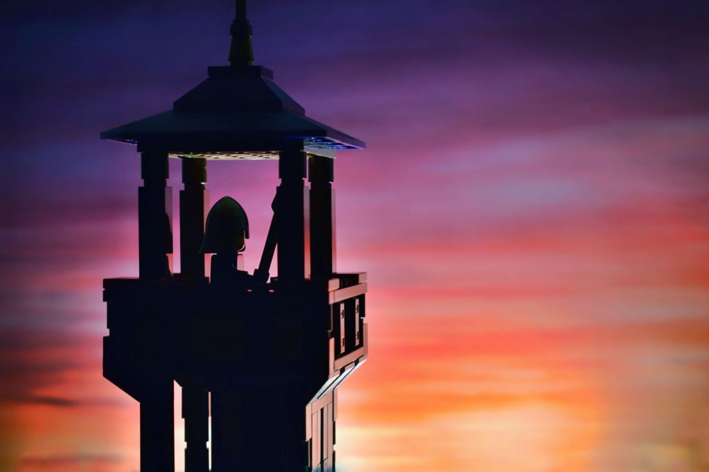 LEGO castle tower and guard silhouettes in the sunset