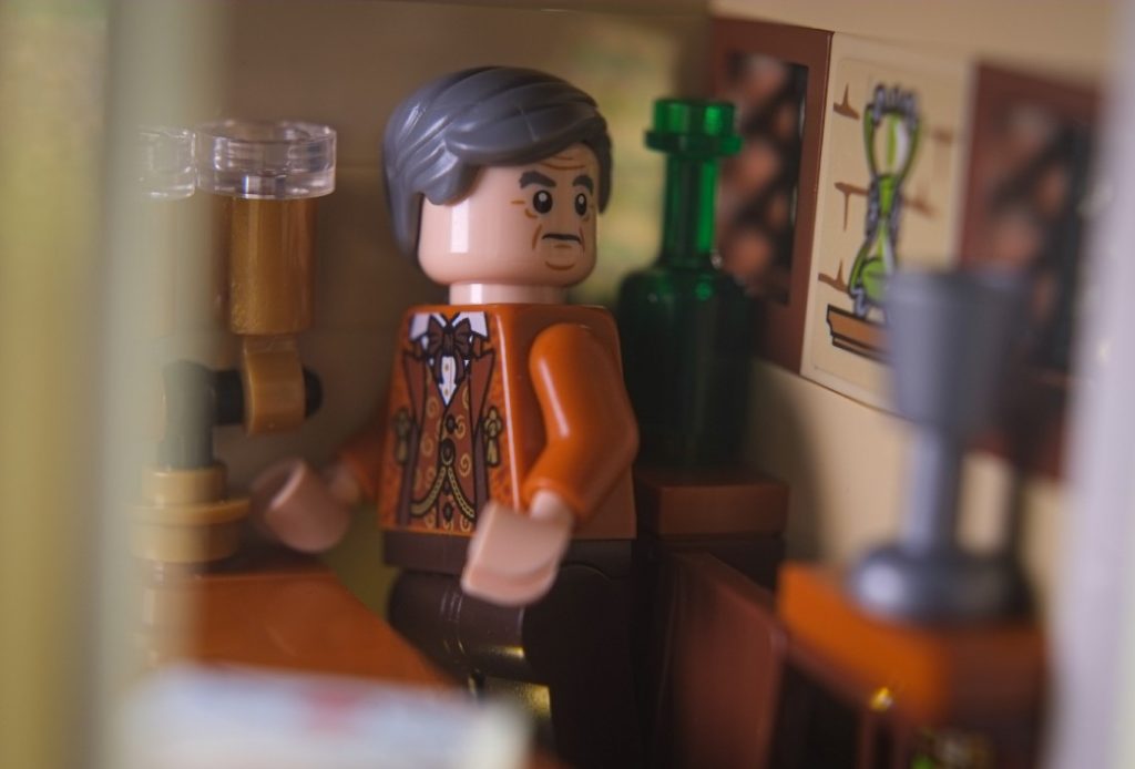 Horace Slughorn LEGO minifigure in his office, looking at the hourglass
