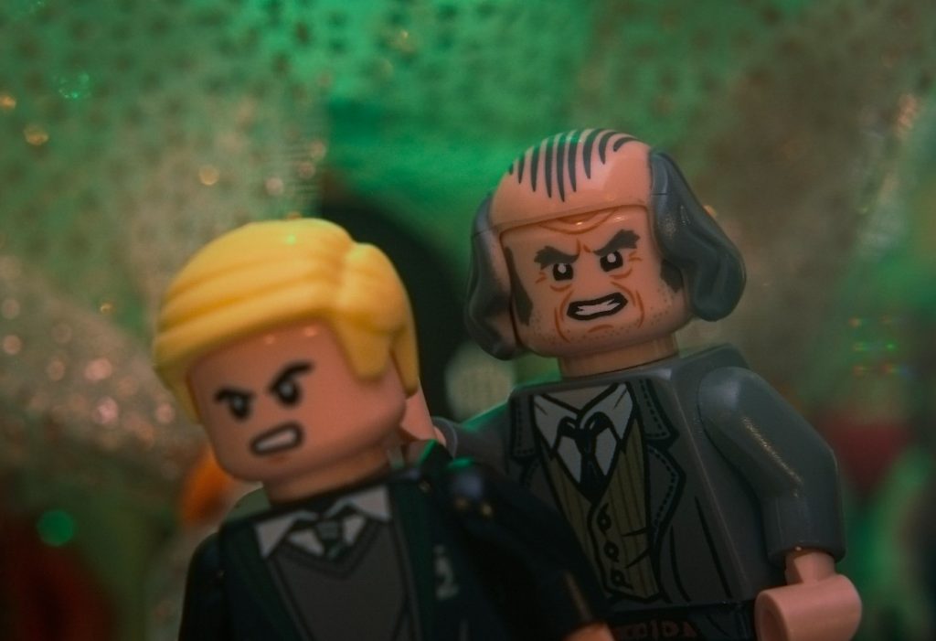 Argus Filch LEGO minifigure capturing a Draco Malfoy LEGO minifigre during Slug Club Christmas party