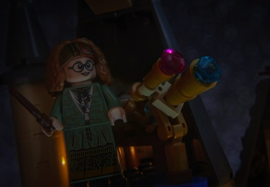 Sybilla Trelawney LEGO minifigure standing on the top of Astronomy Tower, next to the telescope, looking at the starry sky