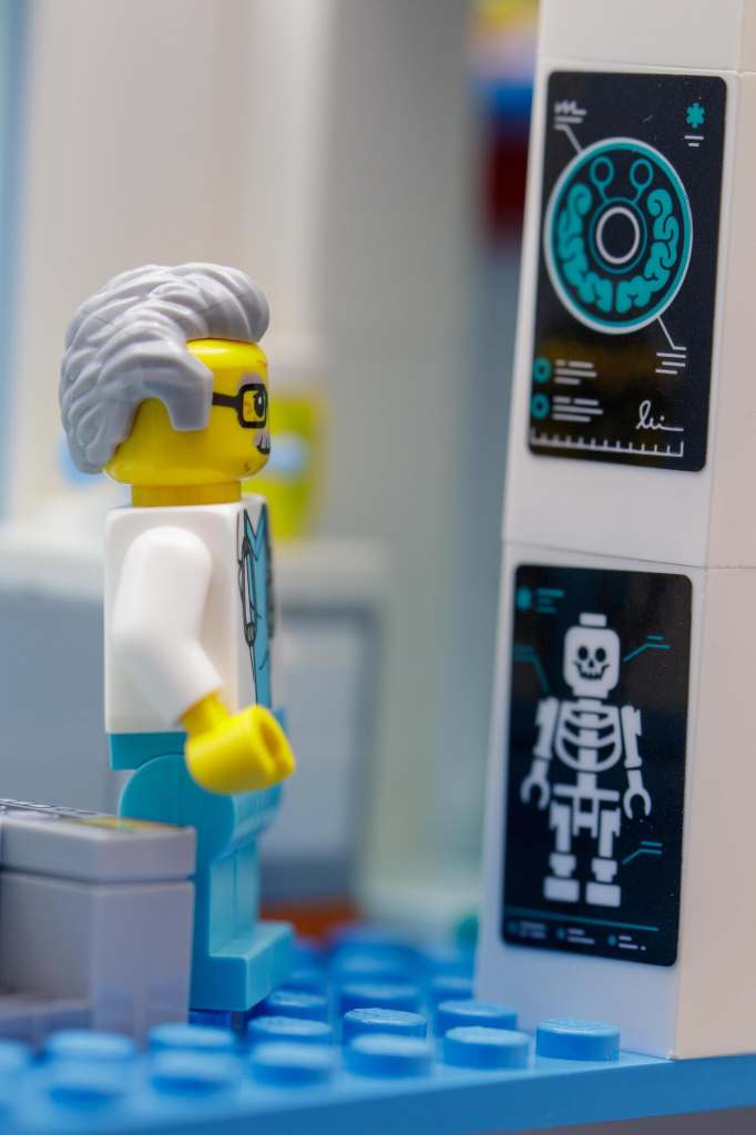 LEGO doctor minifigure looking at printed MRI scans