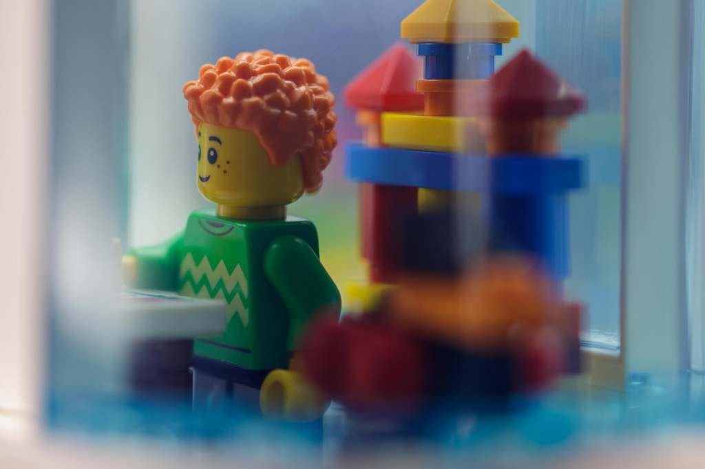 LEGO boy minifigure standing by the toy castle in playroom