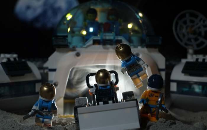 a group of Lego astronauts leaving a Moon base