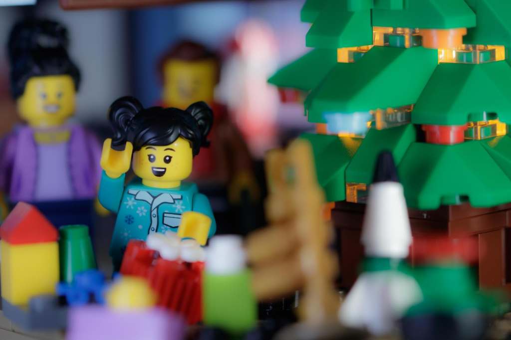 a child Lego kinifigure standing by the presents neath the brick built Christmas tree