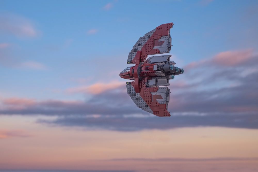 A LEGO 75362 T-6 shuttle model flying towards setting sun