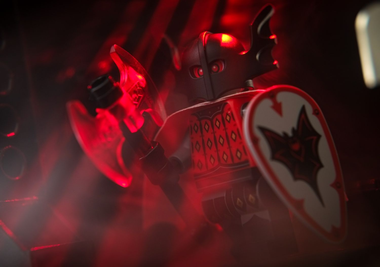 A LEGO Bat Lord minifigure in helmet, holding a trans red axe and a shield.