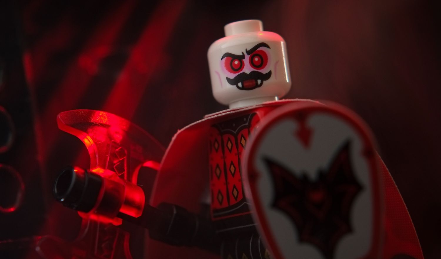 A LEGO Bat Lord minifigure holding a trans red axe.