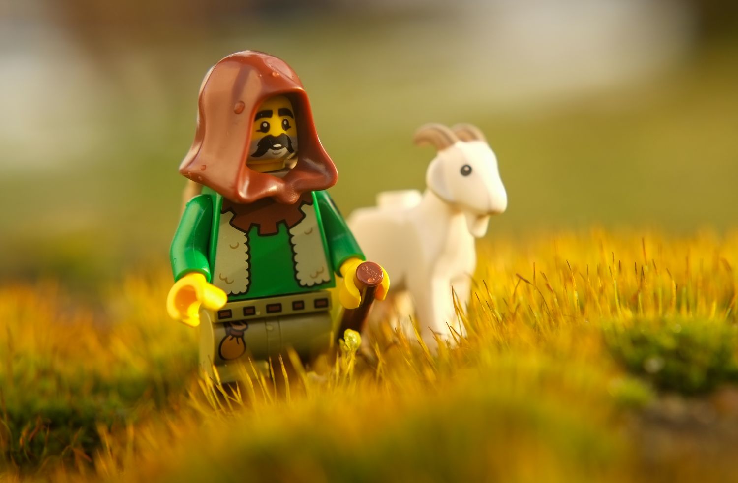 A LEGO goat sheperd strolling on moss.