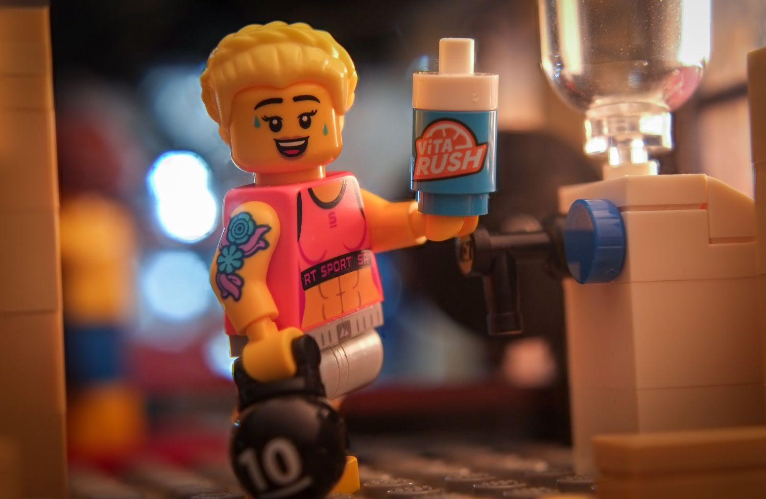 A LEGO Fitness Instructor holding a kettlebell and VIta Rush cup.