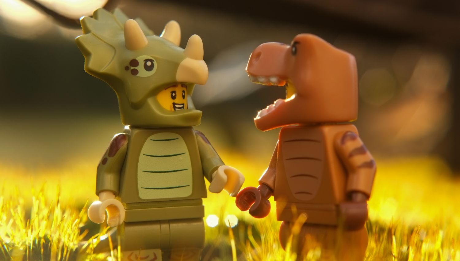 A LEGO Triceratops Costume Fan chatting with T-Rex Costume Fan.
