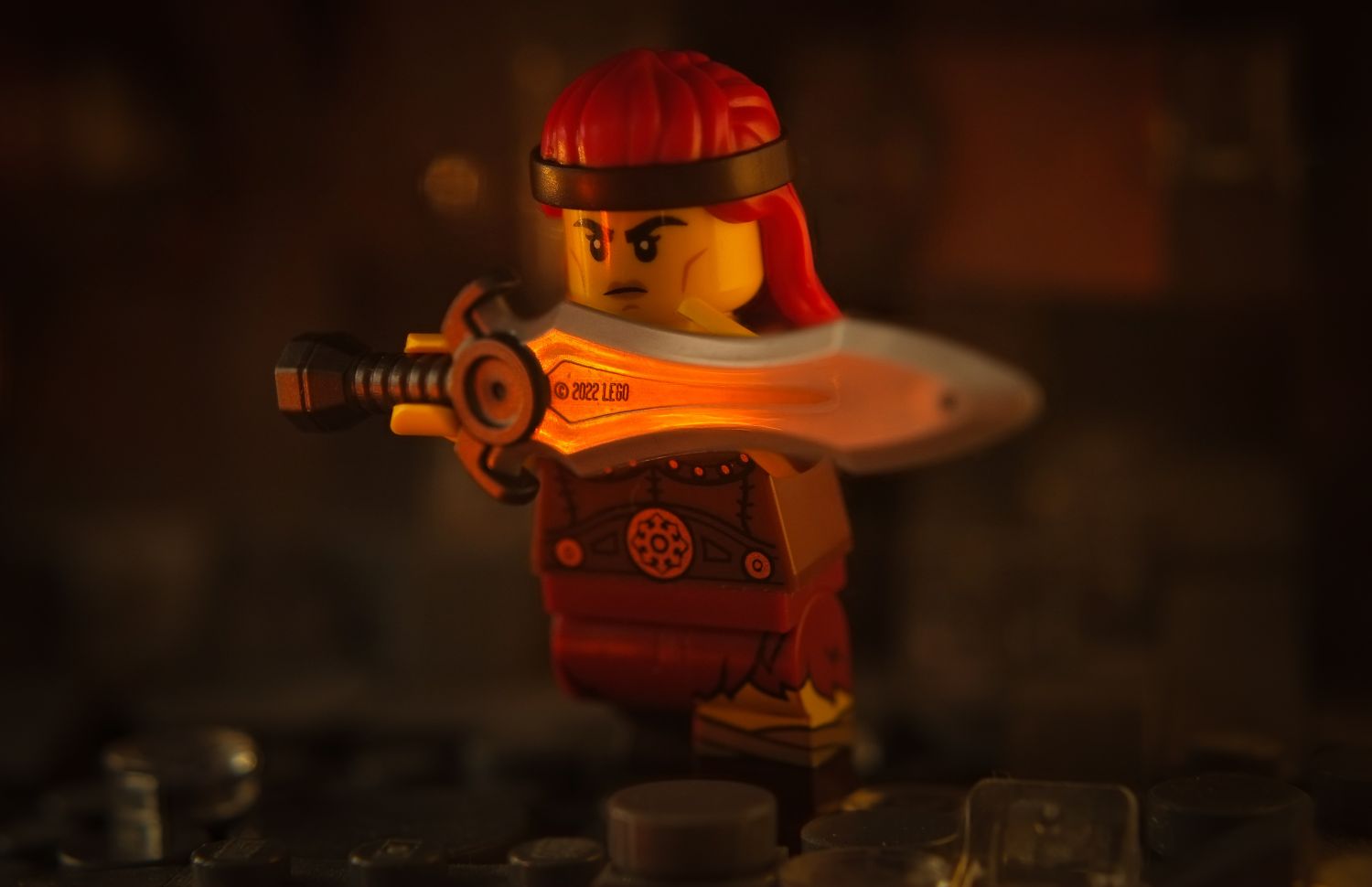 A LEGO barbarian minifigure holding a sword in front of her.