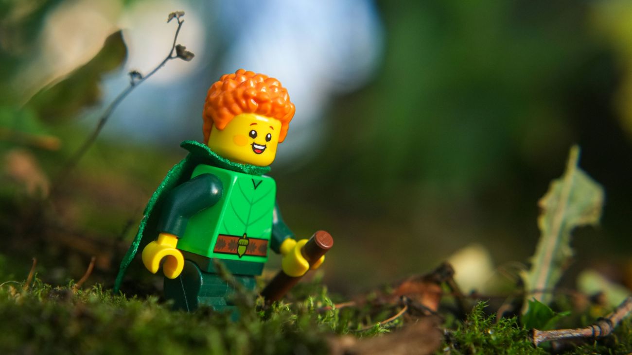 A forest elf LEGO minifigure leaving with the orange hair, walking through the forest