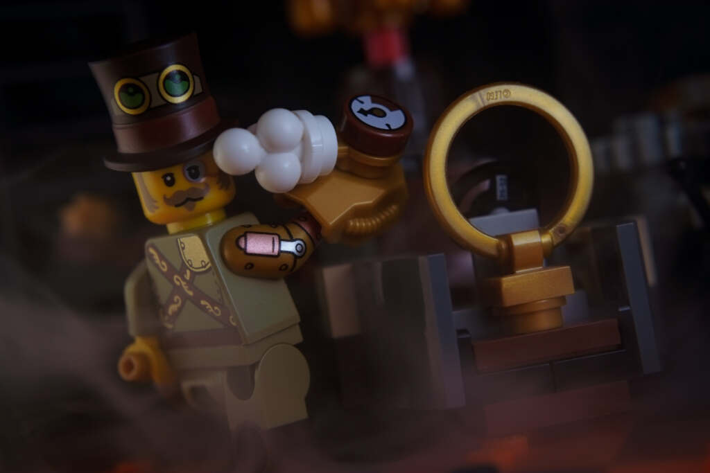 Steampunk Inventor minifigure turns his head while screwing something into the time machine in front of him.